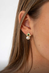 Side profile of model wearing Verona earrings with freshwater pearls and green emerald accents