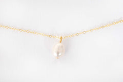 Elisette Pearl Choker displayed on soft fabric showing natural pearl luster and gold accents