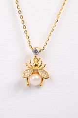 close-up of bee pearl pendant on 18k gold plated chain