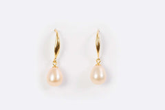 Close-up of Droplet Chic freshwater pearl earrings in gold setting