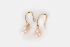 Close-up of Droplet Chic freshwater pearl earrings in gold setting