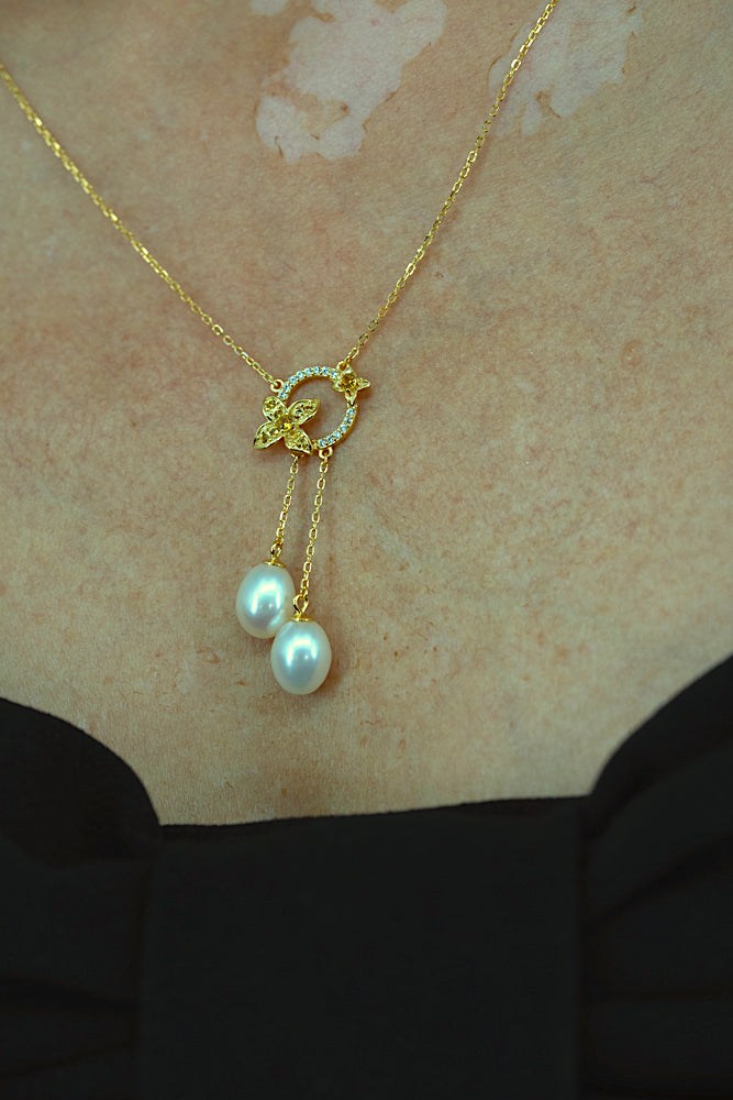 Close-up of Fleur de Perle necklace featuring pearl drop and yellow zircon stones on 18K gold plated sterling silver