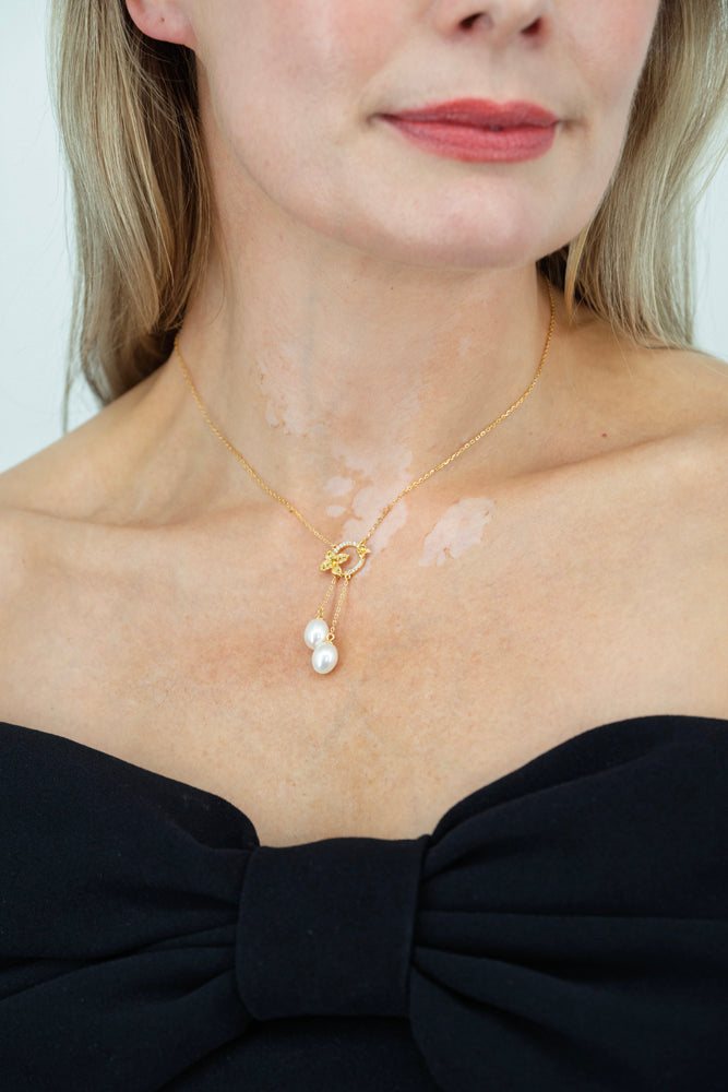 Close-up of Fleur de Perle necklace featuring pearl drop and yellow zircon stones on 18K gold plated sterling silver
