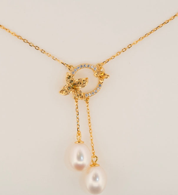 Close-up of Fleur de Perle necklace featuring pearl drop and yellow zircon stones on 18K gold plated sterling silver
