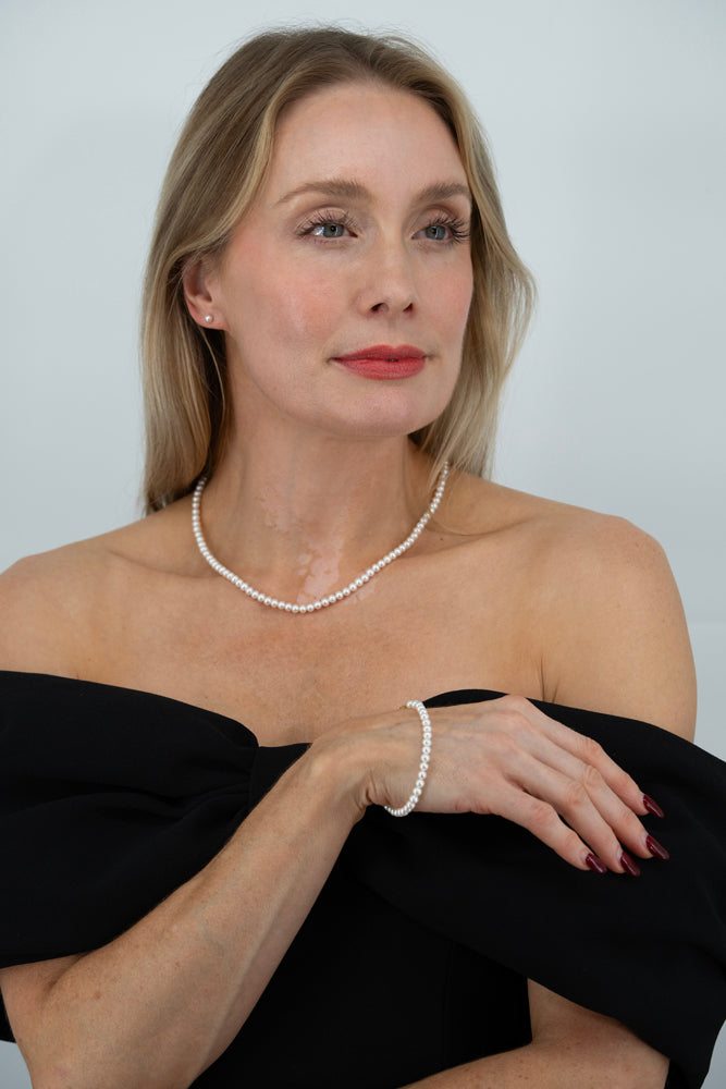 Woman wearing the Royale Pearlisma Pearl Set with AAA freshwater pearls and 18K gold plated sterling silver