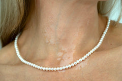 Close-up of Royale Pearlisma AAA freshwater pearl necklace and earrings crafted in sterling silver with gold plating