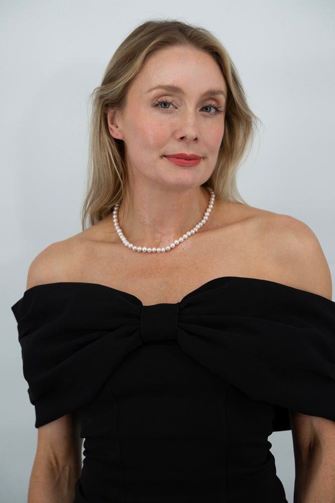 Flat lay of Royale Pearlisma Pearl Necklace with round AAA freshwater pearls and sterling silver clasp