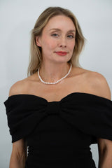 Flat lay of Royale Pearlisma Pearl Necklace with round AAA freshwater pearls and sterling silver clasp