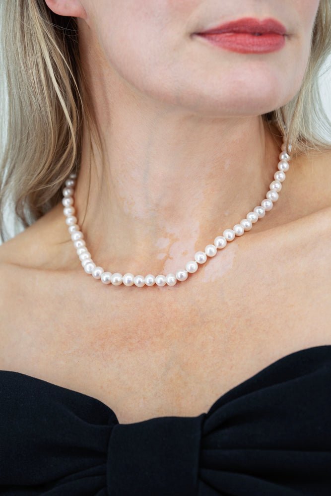 Freshwater pearl choker-style necklace with 18K gold plated clasp on model