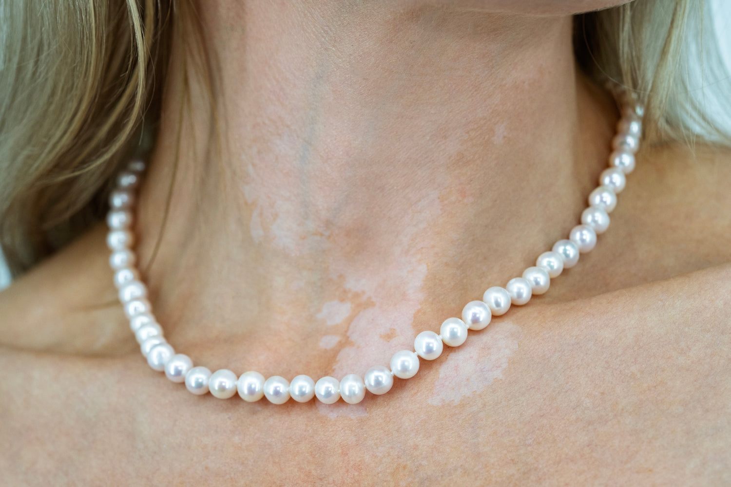 Freshwater pearl choker-style necklace with 18K gold plated clasp on model