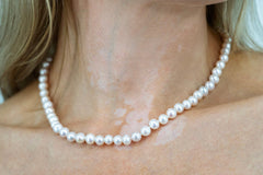 Freshwater pearl choker-style necklace with 18K gold plated clasp on model