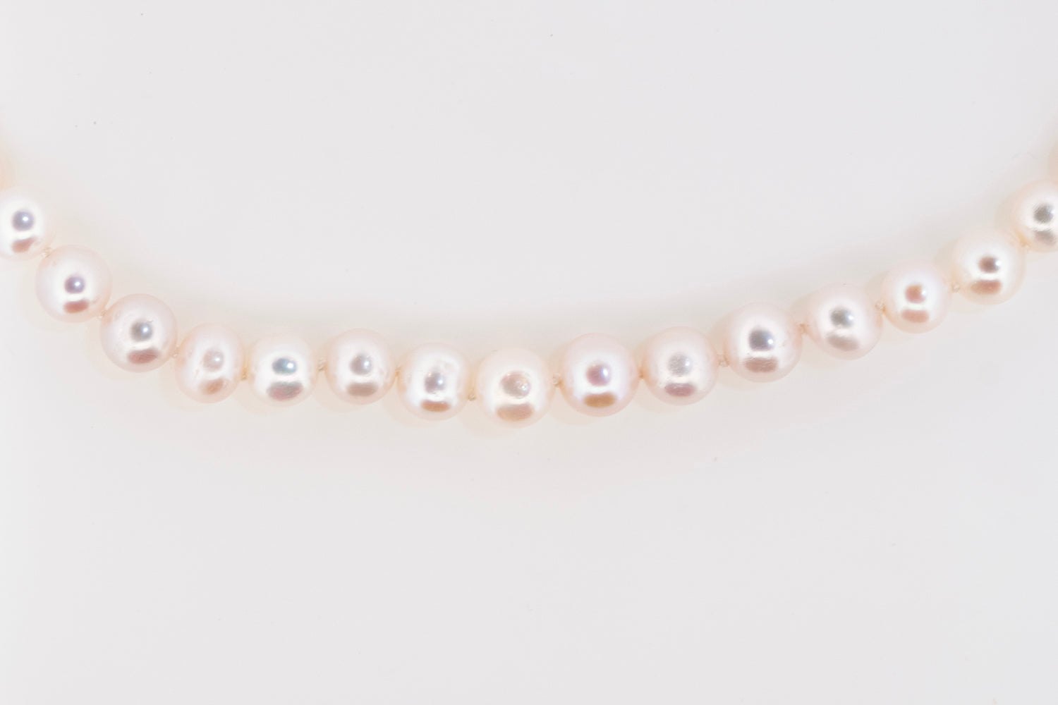 Flat lay of Royale Pearlisma Pearl Necklace with round AAA freshwater pearls and sterling silver clasp