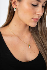 Woman wearing Verona pearl and emerald necklace with gold plated sterling silver chain