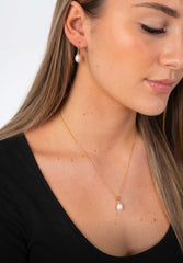 Woman wearing Droplet Chic freshwater pearl earrings with subtle gold plated finish