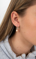 stylish pearl cascade earrings photographed in minimal studio lighting