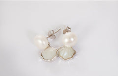Woman wearing Shellora freshwater pearl drop earrings in sterling silver shell design