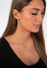 Woman wearing Majestic Lily freshwater pearl necklace with elegant gold plated lily design