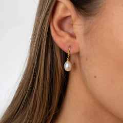 Close-up of Droplet Chic freshwater pearl earrings in gold setting