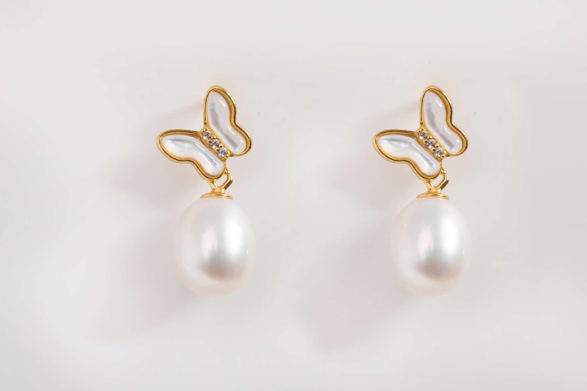 Butterfly Pearl Whisper earrings featuring gold butterfly design with freshwater pearl drops