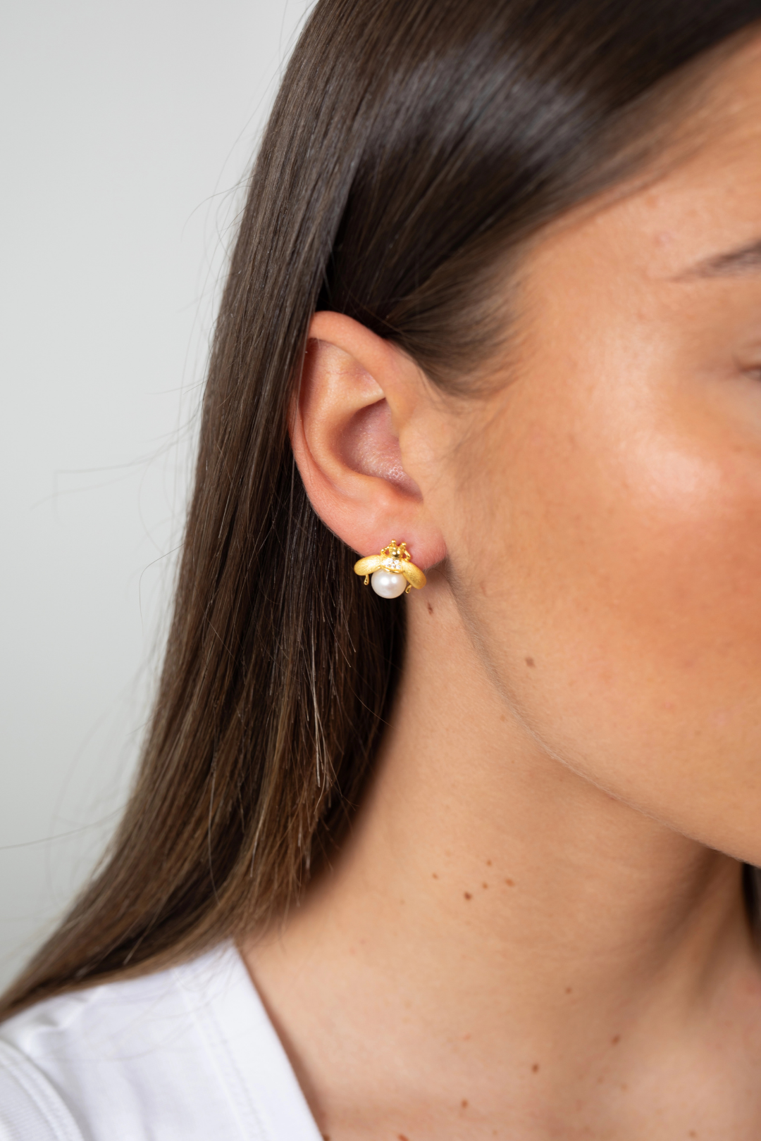 Woman wearing Bee of The Pearl Garden Earrings featuring gold bee motif and freshwater pearl
