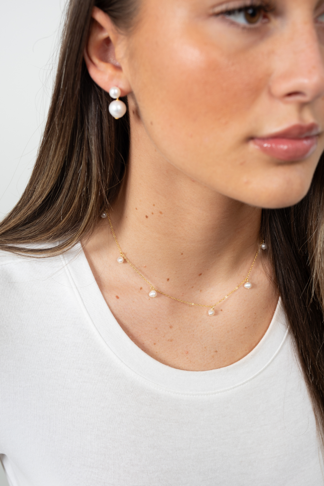 Luna Perle Choker arranged in circular layout with shimmering freshwater pearls and gold accents