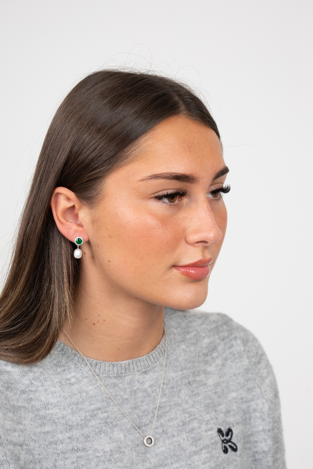 Model wearing Majestic Green Pearl earrings with green jewel and pearl drops