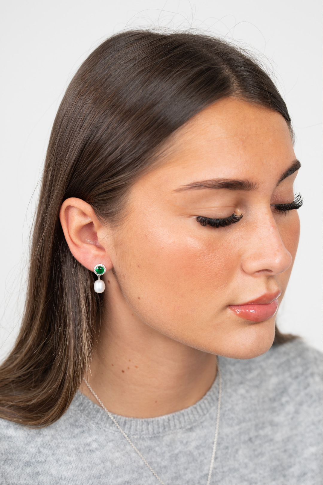 Model wearing Majestic Green Pearl earrings with green jewel and pearl drops