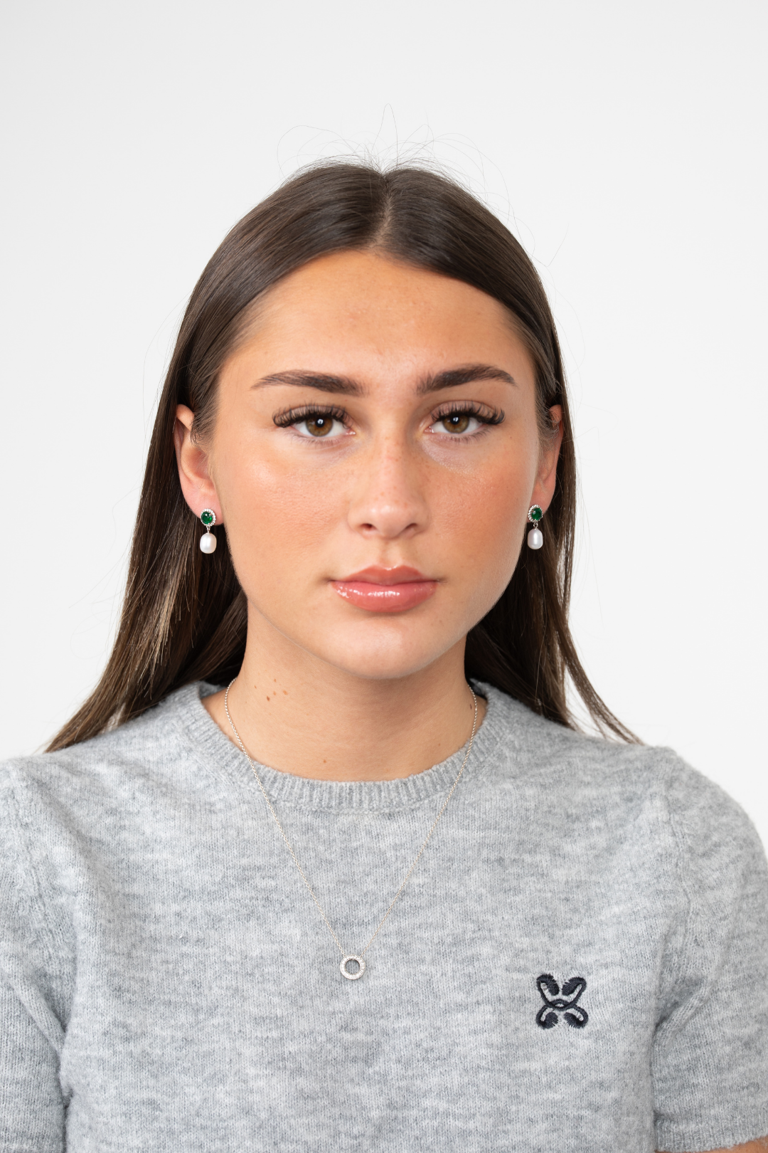 Model wearing Majestic Green Pearl earrings with green jewel and pearl drops