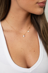 Shellora sterling silver shell earrings with pearl drop shown on textured background